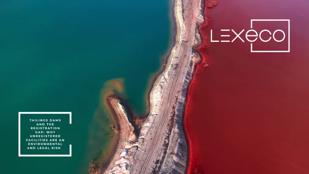 Aerial view of a tailings dam wall separating teal and red water