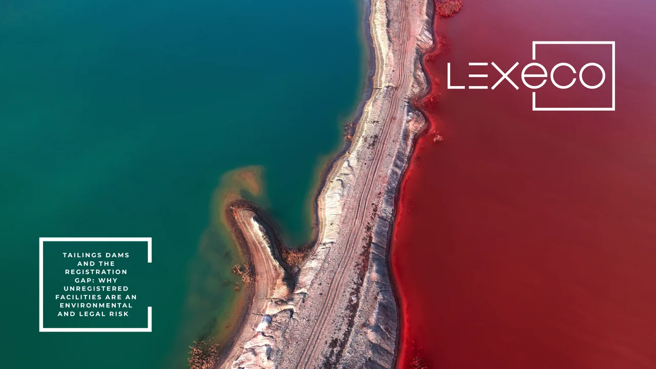 Aerial view of a tailings dam wall separating teal and red water